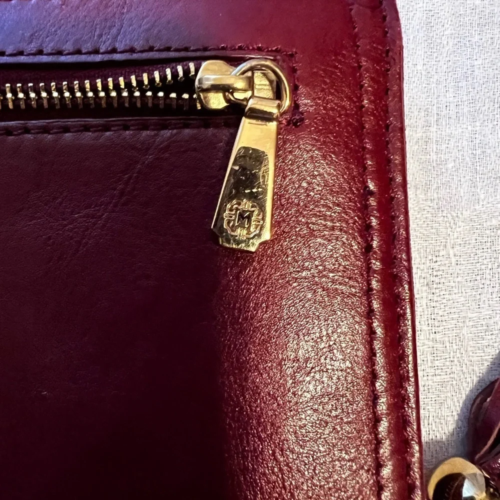 Vintage Monet zip around wallet with tassel on zipper. Maroon in color.